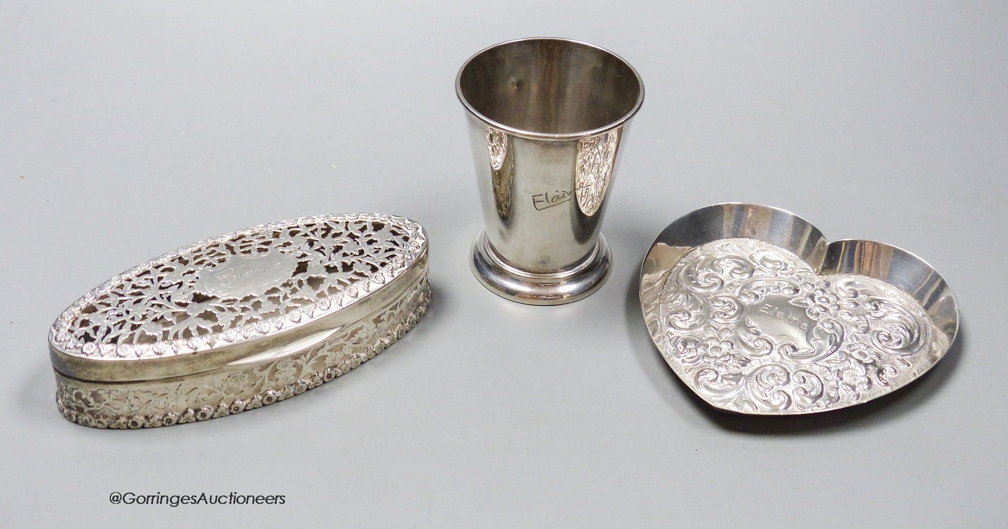 An Edwardian pierced silver oval pot pourri box, Chester, 1909,13.6cm a silver heart shaped pin tray and a silver beaker, all engraved with the name Elaine, 8oz.